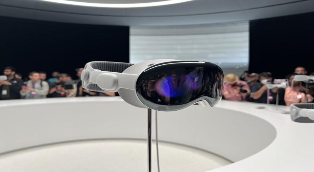 Front view of the Apple Vision Pro mixed-reality headset with curved glass and aluminum frame