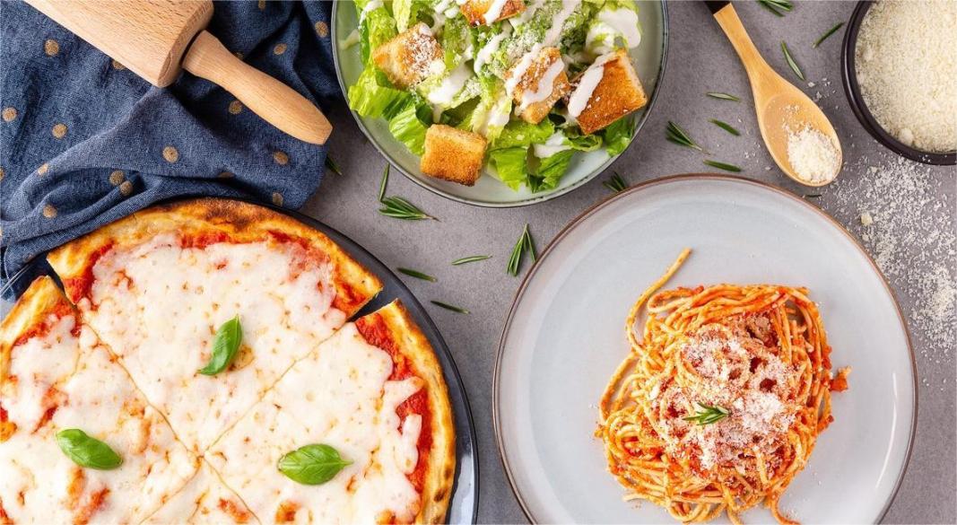 A rustic Italian table with gluten-free pasta, organic sourdough pizza, and fresh farm-to-table ingredients.