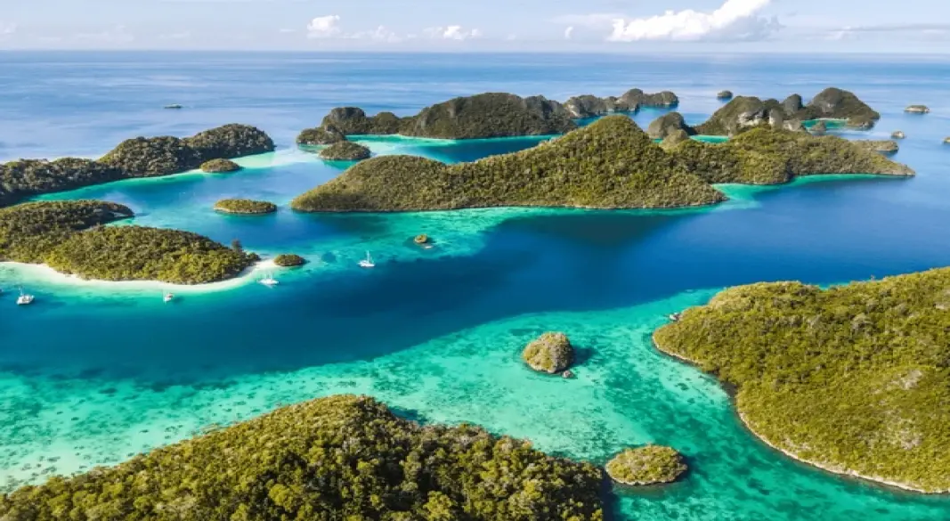 Secluded turquoise bay with lush green cliffs in Raja Ampat, Indonesi