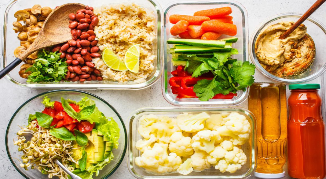 A colorful plate of plant-based foods including vegetables, fruits, grains, and legumes representing vegetarian and vegan diet plans.