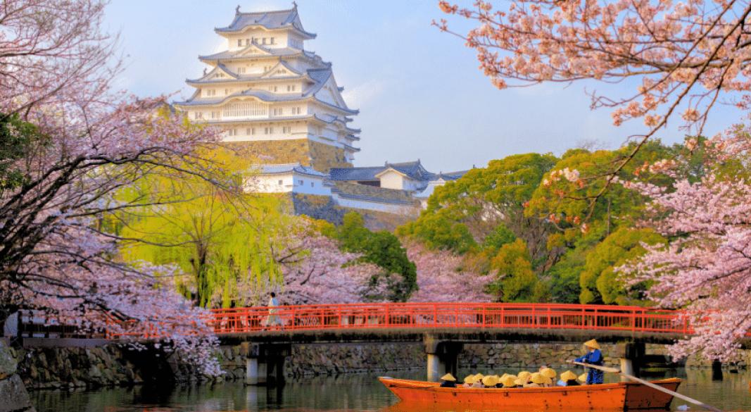 Traditional Japanese pagoda with cherry blossoms and Mount Fuji in the background