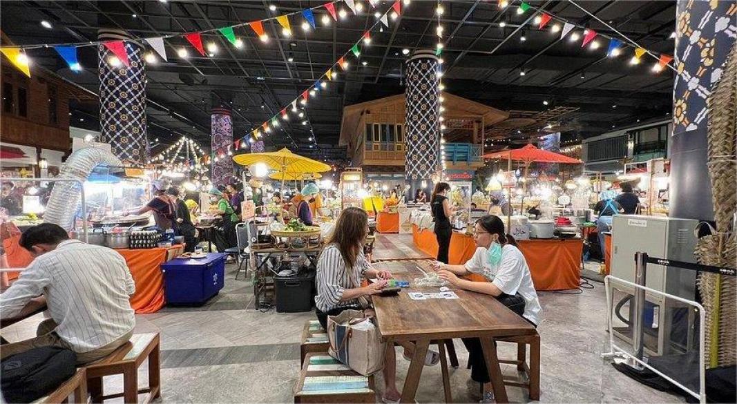 Colorful Thailand street food stall with dishes like Pad Thai noodles, Som Tum papaya salad, grilled satay skewers, and mango sticky rice served at a Bangkok night market