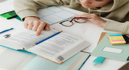 A student using books, laptop, and notes with effective study techniques