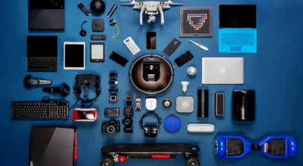 Modern gadgets including smartphone, smartwatch, and wireless earbuds on a desk