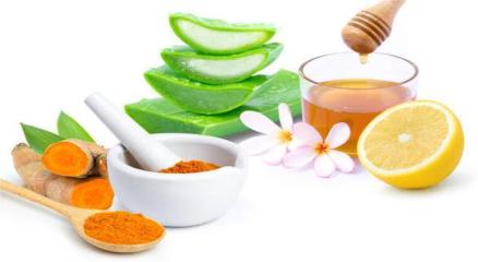 Natural skincare ingredients like honey, turmeric, and lemon placed on a wooden table