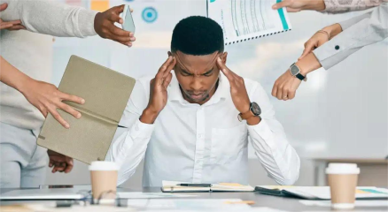 Stressed employee at workplace showing signs of burnout and mental health challenges