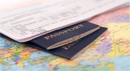 Traveler holding a passport and boarding pass in front of a world map