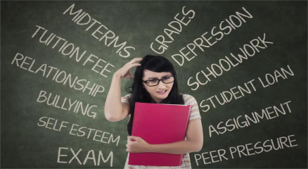 A stressed student surrounded by books and a laptop, holding their head in frustration, symbolizing anxiety and depression caused by heavy academic workload.
