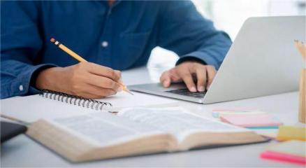 Young learner attending an online course with headphones and laptop