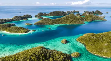 Secluded turquoise bay with lush green cliffs in Raja Ampat, Indonesi