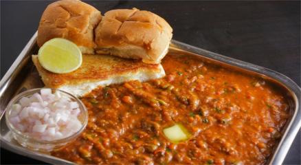 Plate of colorful Pav Bhaji served with butter-toasted pav, garnished with coriander and lemon