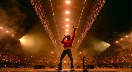 Famous music celebrity performing live on stage with fans cheering
