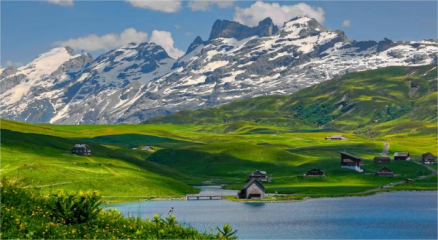 "Scenic view of the Swiss Alps with snowy mountains, green valleys, and a clear lake"